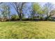 Large grassy backyard with mature trees and a wooden fence in the background at 181 Bernice Dr, Lawrenceville, GA 30045