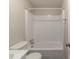 Bathroom featuring a toilet, white tub, and shower combo with a tiled surround and updated fixtures at 181 Bernice Dr, Lawrenceville, GA 30045