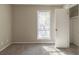 Neutral bedroom featuring gray carpeting, large window with blinds, and a closet with open door at 181 Bernice Dr, Lawrenceville, GA 30045