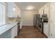 Bright kitchen features stainless steel appliances, white cabinets, light countertops, and wood floors at 181 Bernice Dr, Lawrenceville, GA 30045