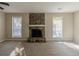 Living room with a large stone fireplace as a focal point flanked by sunlit windows at 181 Bernice Dr, Lawrenceville, GA 30045