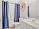 Cozy bathroom featuring a vanity, toilet, and shower with blue curtains and nautical decor at 1929 Lake Heights Nw Cir # 2, Kennesaw, GA 30152