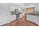 Open kitchen with hardwood floors, white cabinets, stainless oven, and an adjacent dining area at 1929 Lake Heights Nw Cir # 2, Kennesaw, GA 30152