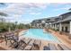 Resort-style pool area with lounge chairs, tables, and community buildings in the background at 6626 Sterling Dr, Sandy Springs, GA 30328