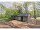 View of the home's backyard, featuring a patio, gray siding and mature trees at 1803 Gingham Ct, Lithonia, GA 30058