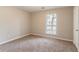 A simple bedroom with neutral carpet, a window with blinds, and a white door at 1803 Gingham Ct, Lithonia, GA 30058