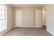 Neutral-toned bedroom with carpeted floors, bright window, and closet space at 1803 Gingham Ct, Lithonia, GA 30058
