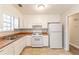 Bright kitchen featuring white appliances, laminate countertops and white cabinetry at 1803 Gingham Ct, Lithonia, GA 30058