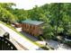 Exterior view of a historic mill building with a green roof, surrounded by a scenic view of trees and river at 225 Maison Court, Roswell, GA 30076