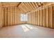 Bright unfinished room with natural light streaming through the window, highlighting the wood framing and construction at 225 Maison Court, Roswell, GA 30076