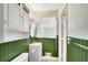 Lovely bathroom featuring green paneled walls, a white sink, and a window with curtains at 4535 Forest Green Dr, Sugar Hill, GA 30518
