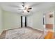 Comfortable bedroom with a ceiling fan and a door to the hallway, and neutral toned walls at 4535 Forest Green Dr, Sugar Hill, GA 30518