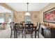 A dining room with tan walls, featuring a wooden table, six chairs, and a decorative floral painting above a buffet table at 4535 Forest Green Dr, Sugar Hill, GA 30518