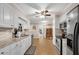 Galley kitchen featuring white cabinets, granite countertops, stainless steel appliances, and a view of rooms through doorways at 4535 Forest Green Dr, Sugar Hill, GA 30518