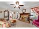 Living room with a brick fireplace, wood mantle and trim, ceiling fan and view into another room at 4535 Forest Green Dr, Sugar Hill, GA 30518