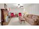 Living room with brick fireplace, ceiling fan, plaid sofa, red chairs and a view into another room at 4535 Forest Green Dr, Sugar Hill, GA 30518