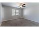 This sunny bedroom offers soft carpet, neutral walls, and a ceiling fan for comfort at 2030 Hilda Burns Pl, Lithonia, GA 30058