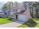 Charming tan two-story home featuring an attached one car garage and a driveway at 2030 Hilda Burns Pl, Lithonia, GA 30058