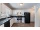 Galley kitchen with stainless steel appliances, dark countertops, and white cabinetry at 2030 Hilda Burns Pl, Lithonia, GA 30058