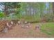 Backyard fire pit with seating area and ample wood storage, perfect for outdoor gatherings at 6909 Heritage Pl, Acworth, GA 30102