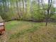 Large backyard featuring a wood fence, wood storage, a pathway, and surrounding trees for privacy at 6909 Heritage Pl, Acworth, GA 30102
