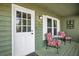 Inviting front porch featuring floral print furniture, complemented by a white door and decorative wall art at 6909 Heritage Pl, Acworth, GA 30102