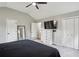 Rear view of main bedroom with closet, television, full-length mirror, and neutral colors throughout at 6909 Heritage Pl, Acworth, GA 30102