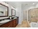 Bright bathroom with double vanity, granite countertops, framed mirrors, soaking tub, and tiled shower at 865 Inman Village Ne Pkwy, Atlanta, GA 30307