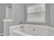 Bathroom featuring a large soaking tub next to a bright, large window at 240 Springbottom Ct, Lawrenceville, GA 30046