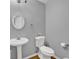 Cozy bathroom featuring a pedestal sink, decorative mirror, and essential toiletries at 240 Springbottom Ct, Lawrenceville, GA 30046
