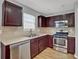 Well-equipped kitchen features stainless steel appliances, wood cabinets, and modern countertops at 240 Springbottom Ct, Lawrenceville, GA 30046