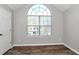 The bedroom features gray walls, wood floors, a large arched window, and a door at 2590 Carolina Rdg, Riverdale, GA 30296