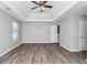 The main bedroom features a tray ceiling, ceiling fan, wood-look floors, and multiple windows at 2590 Carolina Rdg, Riverdale, GA 30296