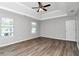 Bright main bedroom with tray ceiling, wood-look floors, multiple windows, and a ceiling fan at 2590 Carolina Rdg, Riverdale, GA 30296