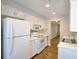 Well lit kitchen with white appliances, white cabinetry, and hardwood floors and neutral paint scheme at 2929 Torreya Se Way, Marietta, GA 30067