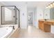 Large bathroom featuring a stand up shower, soaking tub, double sink vanity, and tiled floors at 5658 Greensage Dr, Atlanta, GA 30349