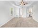 A spacious bedroom with bay windows, tray ceilings, carpet floors, and ceiling fan at 5658 Greensage Dr, Atlanta, GA 30349