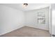 A cozy bedroom featuring neutral carpet and white walls with a bright window at 5658 Greensage Dr, Atlanta, GA 30349