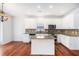 Bright kitchen features white cabinets, stainless steel appliances, granite countertops and hardwood floors at 5658 Greensage Dr, Atlanta, GA 30349