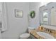 Cozy powder room with granite countertop, decorative mirror and wreath at 93 Hammock Se Pl, Atlanta, GA 30312