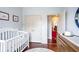 Bedroom featuring hardwood floors, a crib, a changing table, and a large closet at 93 Hammock Se Pl, Atlanta, GA 30312