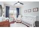 Bedroom featuring hardwood floors, a ceiling fan, a crib, and large windows at 93 Hammock Se Pl, Atlanta, GA 30312