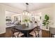 Formal dining room with modern lighting fixture and views of the kitchen and living room at 9640 Cedar Grove Rd, Fairburn, GA 30213