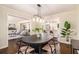 Open dining area with modern light fixture and hardwood floors, opens to the kitchen and living areas at 9640 Cedar Grove Rd, Fairburn, GA 30213
