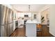 Bright kitchen boasts stainless steel appliances, white cabinetry, island, and dark hardwood floors at 9640 Cedar Grove Rd, Fairburn, GA 30213