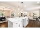 Bright, open kitchen with white cabinets and an island leading to the living area at 9640 Cedar Grove Rd, Fairburn, GA 30213