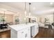 Open concept kitchen with island and pendant lights, connecting to the living area at 9640 Cedar Grove Rd, Fairburn, GA 30213
