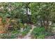 Secluded backyard featuring a stone pathway, treehouse, and fire pit surrounded by lush greenery at 966 Blue Ridge Ne Ave, Atlanta, GA 30306