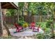 Cozy backyard stone patio with comfortable red chairs shaded by lush trees at 966 Blue Ridge Ne Ave, Atlanta, GA 30306