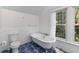 Bright bathroom featuring a clawfoot tub, toilet, and blue tiled floors, offering a comfortable and stylish retreat at 966 Blue Ridge Ne Ave, Atlanta, GA 30306